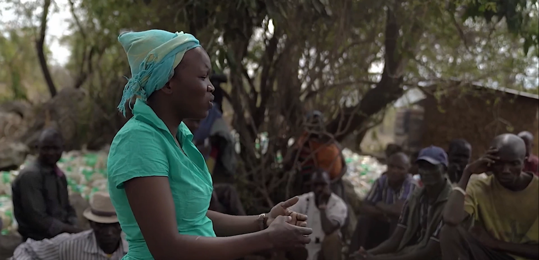 Woman speaks to audience in Uganda