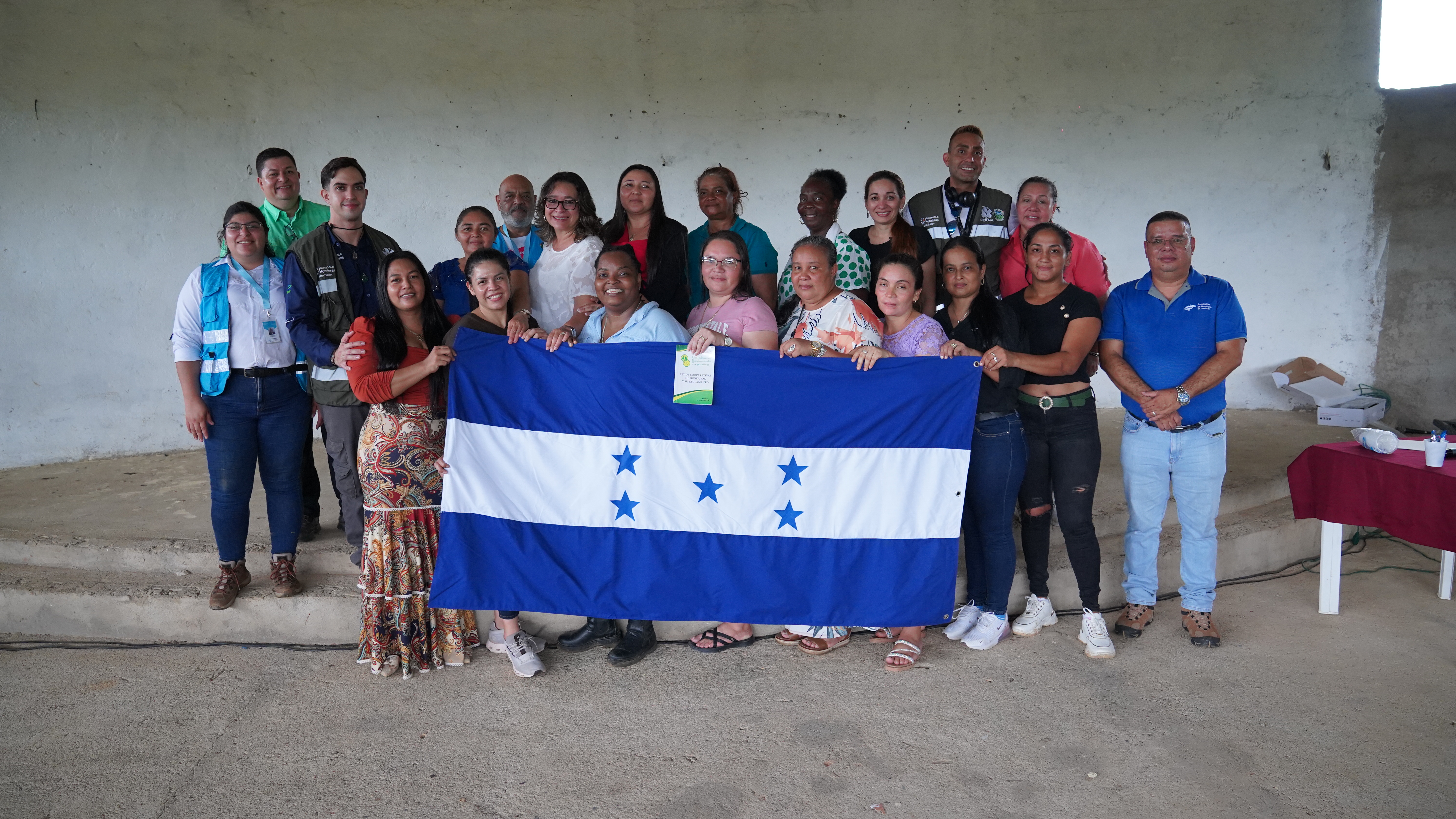 Cooperativa Mixta de Mujeres con la bandera de Honduras