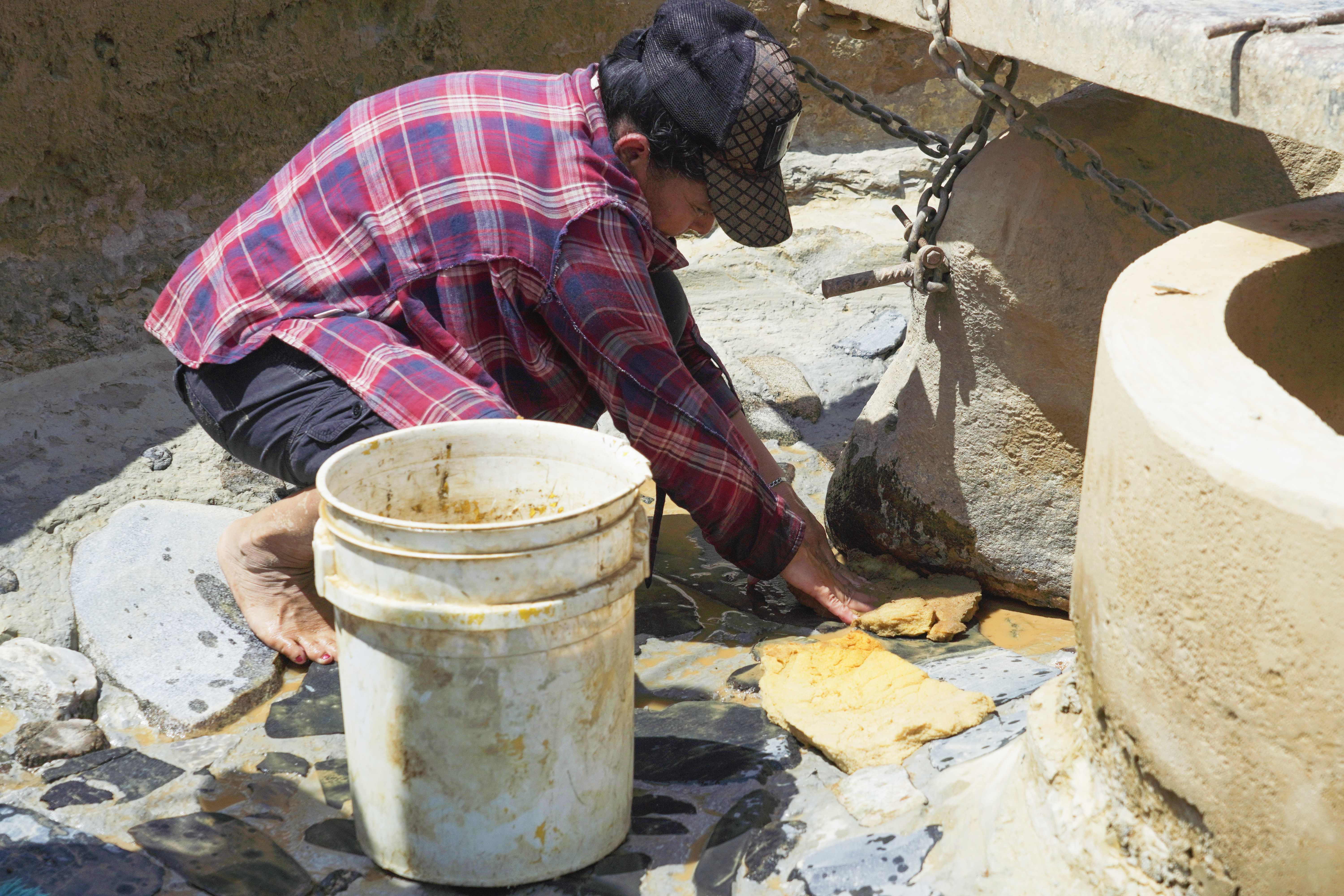 Mujer limpiando molienda artesanal