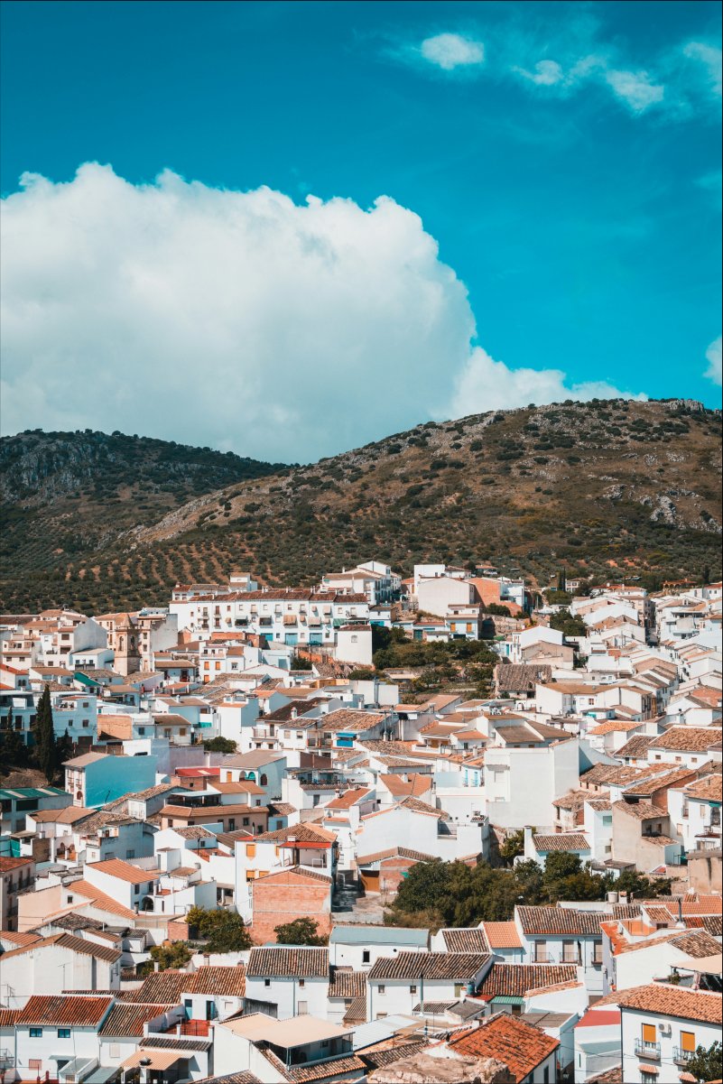 A village of pink roofs and white walls on the face of a hill