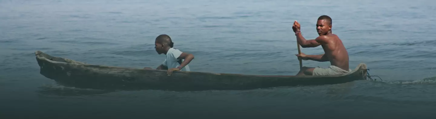 Boys paddle boat in Colombia