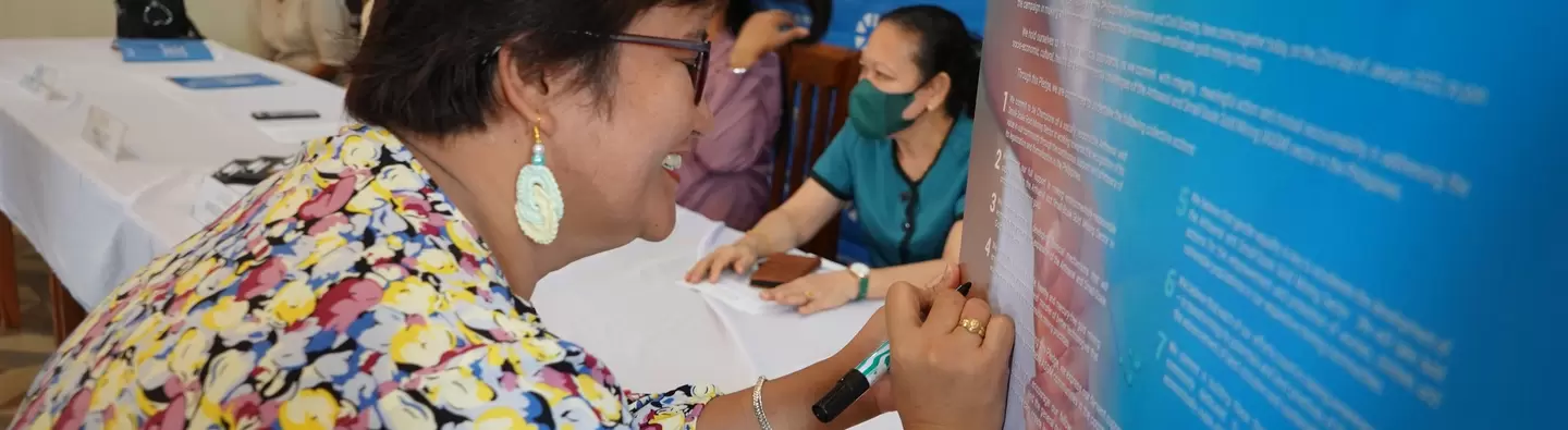 Sarah Aviado, PIO of Camarines Norte Government, signs the Collective Pledge for the People and the Planet