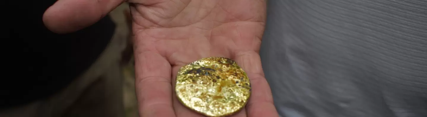 Person holding gold in hand