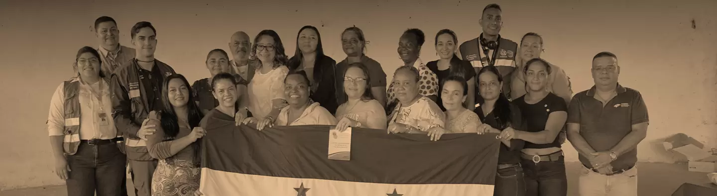 Cooperativa Mixta de Mujeres con la bandera de Honduras