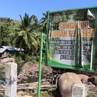 Sign warning of mercury contamination in river in Indonesia