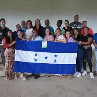 Cooperativa Mixta de Mujeres con la bandera de Honduras