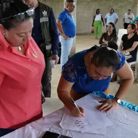 Mujer de la cooperativa firmando la personería jurídica