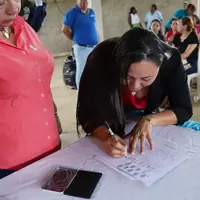 Mujer de la cooperativa firmando la personería jurídica