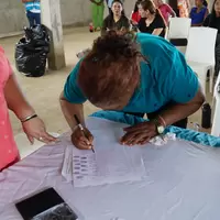 Mujer de la cooperativa firmando la personería jurídica
