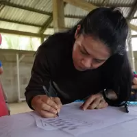 Mujer de la cooperativa firmando la personería jurídica