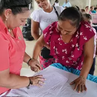 Mujer de la cooperativa firmando la personería jurídica
