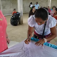 Mujer de la cooperativa firmando la personería jurídica