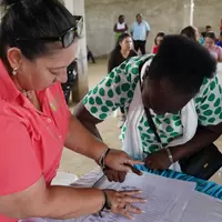 Mujer de la cooperativa firmando la personería jurídica