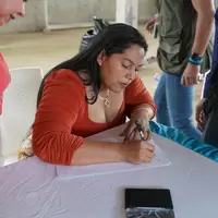 Mujer de la cooperativa firmando la personería jurídica