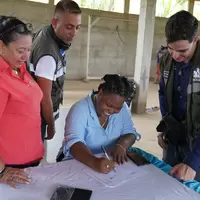 Mujer de la cooperativa firmando la personería jurídica