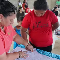 Mujer de la cooperativa firmando la personería jurídica