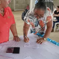 Mujer de la cooperativa firmando la personería jurídica