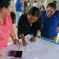 Mujer de la cooperativa firmando la personería jurídica