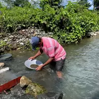 Person panning for gold in water