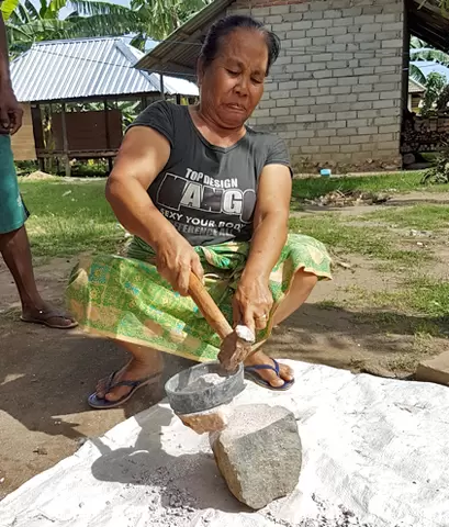 Female miner crushing ore in Sekotong, West Lombok, Indonesia