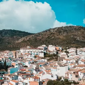 A village of pink roofs and white walls on the face of a hill