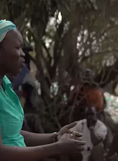 Woman speaks to audience in Uganda