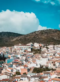 A village of pink roofs and white walls on the face of a hill
