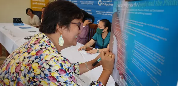 Sarah Aviado, PIO of Camarines Norte Government, signs the Collective Pledge for the People and the Planet