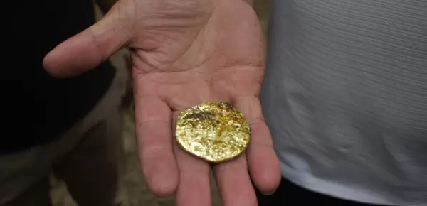 Person holding gold in hand