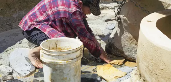 Mujer limpiando molienda artesanal