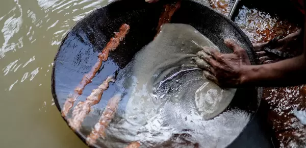 Miner in the Philippines panning for gold using mercury