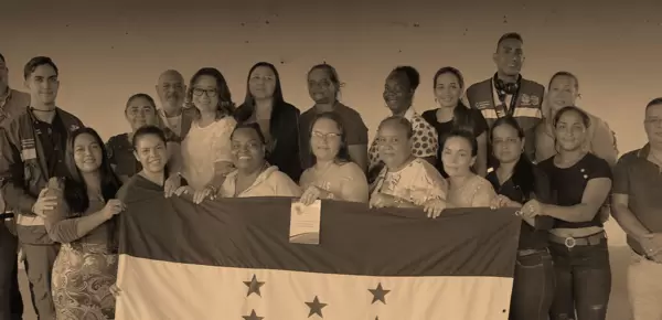 Cooperativa Mixta de Mujeres con la bandera de Honduras